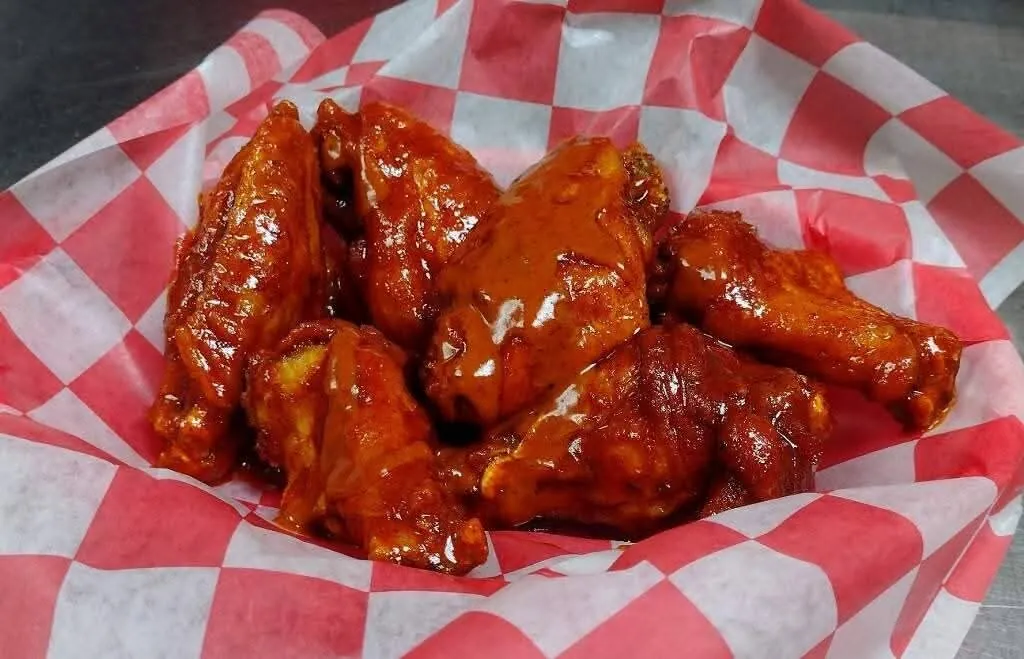 Basket of jumbo wings tossed in BBQ sauce