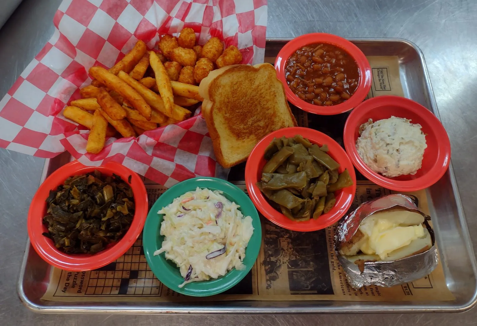 Tray of Southern sides at Roadside Grill: fries, tots, Texas toast, baked beans, potato salad, collard greens, slaw, green beans, and a loaded baked potato