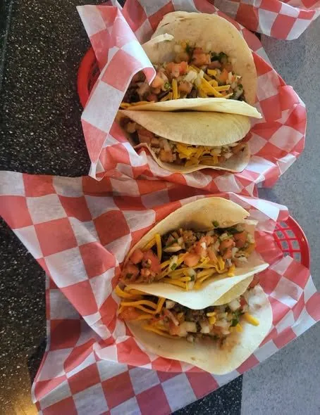 Baskets of homemade beef tacos topped with cheese and pico